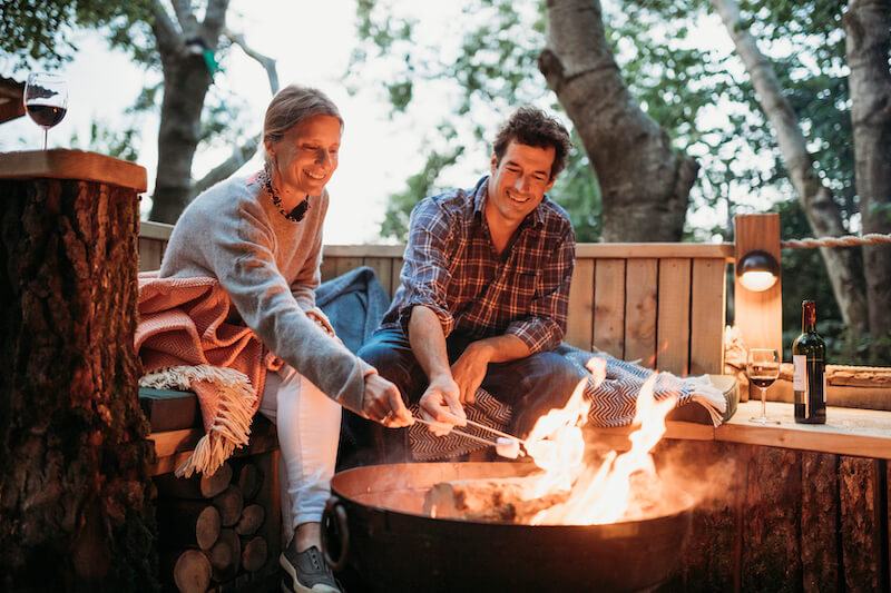 glamping guests toasting marshmallows over a firepit