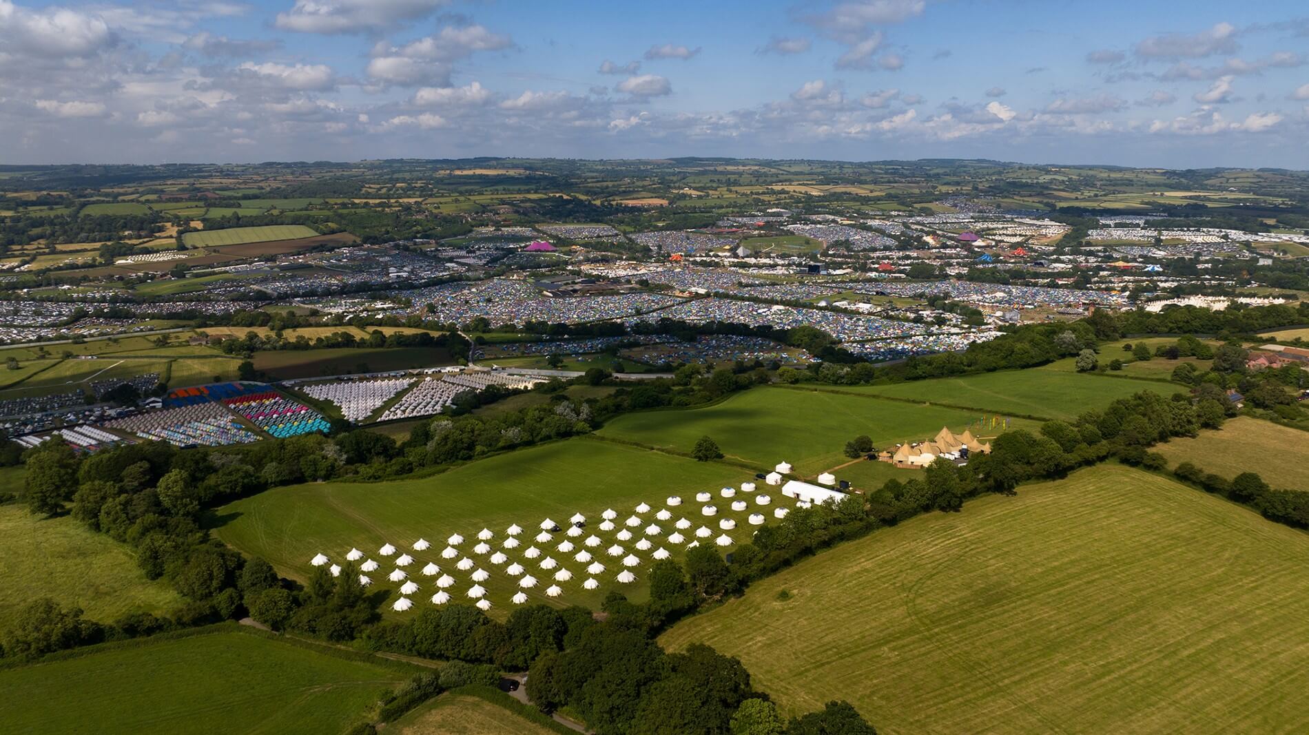 An aerial shot over the Glastonbury Festival site and Pennard Hill Farm Camping Site
